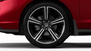 Closeup of wheel on a red Accord on white space.
