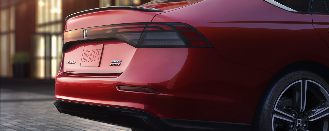 Closeup 3/4 view of the trunk and back wheel fender on a red Accord.
