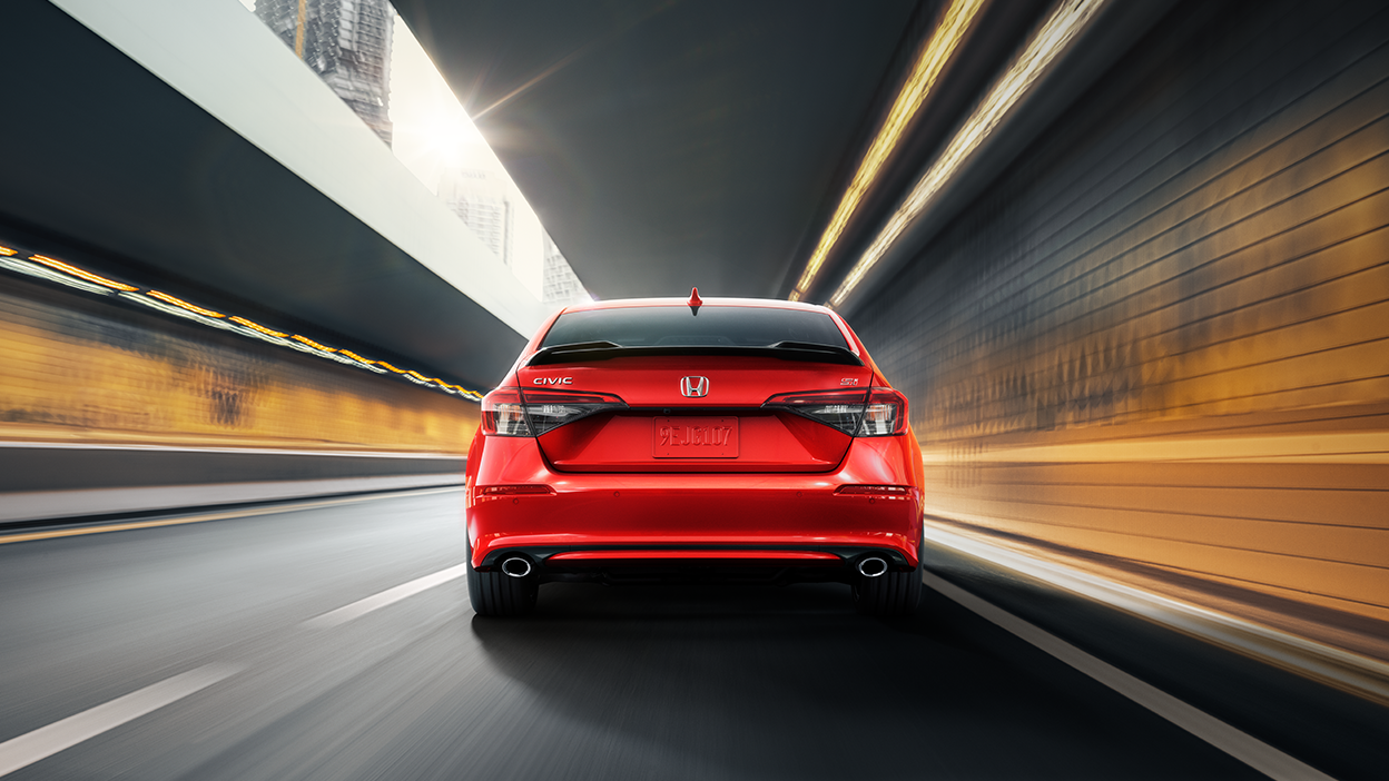 Rearview of red Civic Si driving in tunnel.