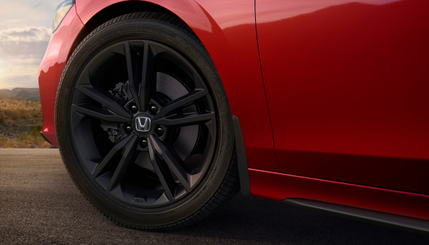 Closeup of black wheel on red Civic Si.