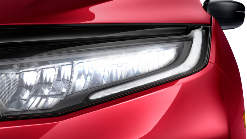 Closeup of headlight on red Odyssey on white space.