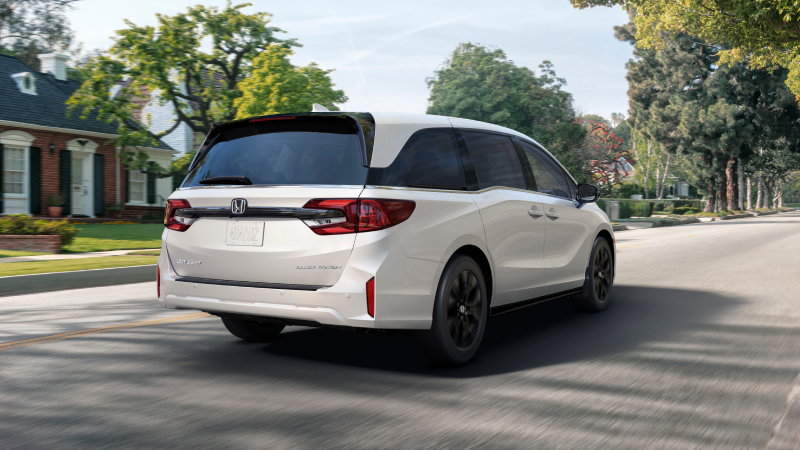 3/4 rear view of white Odyssey braking in suburban street.