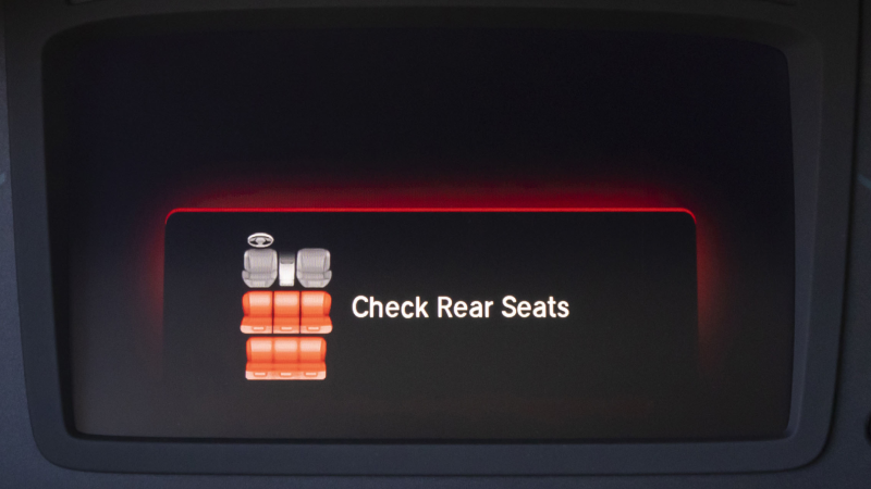 Closeup of “check rear seats” alert on screen.