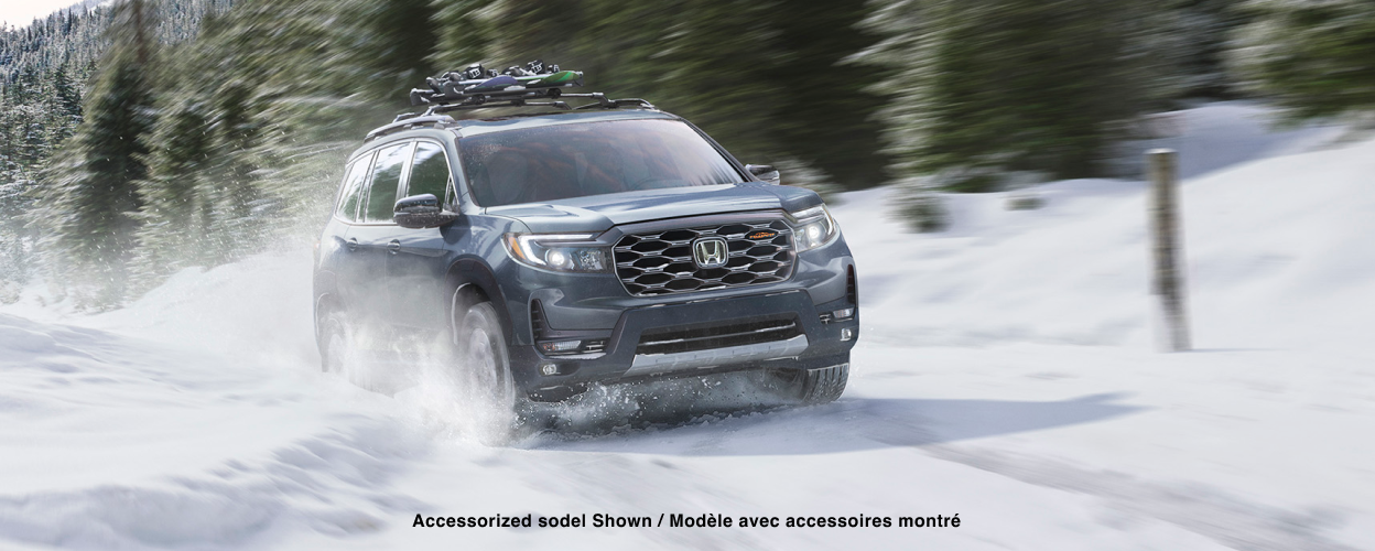 3/4 front view of Passport driving snowy forest road.