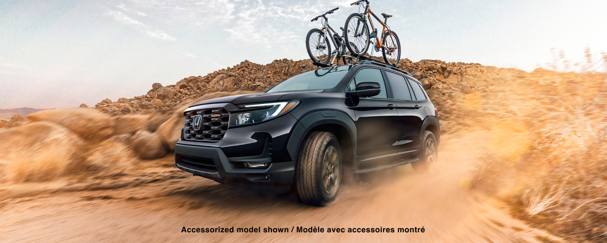 3/4 side front view of black Passport desert off-roading with two bikes on the roof rails.