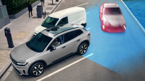 3/4 bird’s eye side view of a Prologue in a parking spot. Blue sensor waves emit from behind, detecting a car crossing behind it.