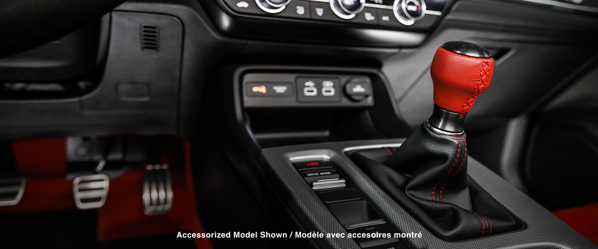 Closeup of shifter with red leather handle and centre console.