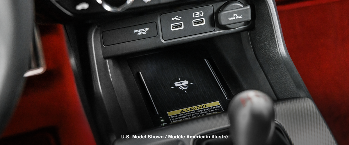 Closeup of wireless charging pad in centre console above gear shifter.